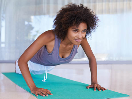 Shot of an attractive young woman doing push-ups on an exercise mat